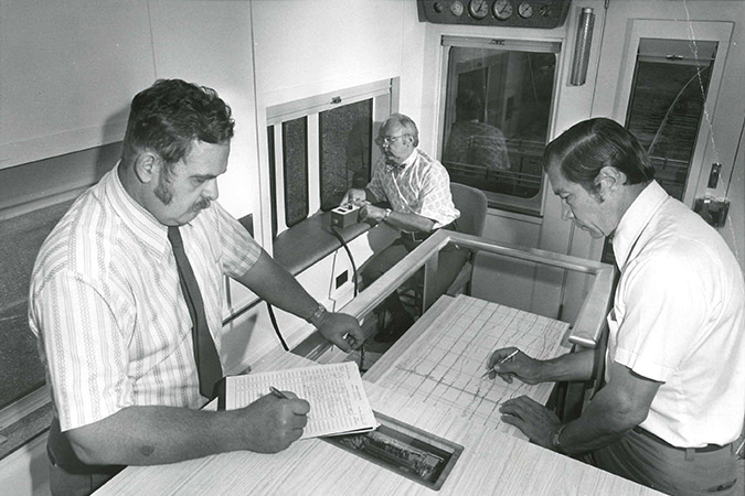 Atchison, Topeka and Santa Fe employees manually review track geometry strip charts on the geo cars in the 1970s.