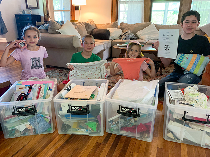 The O’Donnell kids with their memory boxes, from left: Harper, with an art project; Ezra, with his baby blanket; Ivy, with a school hat and newborn onesie; Jones, with a Japanese diploma and a quilt.