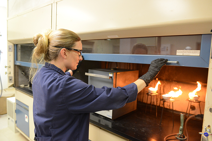 Senior Engineer I Rachel Flott analyzes diesel fuel to determine the ash content. The fuel is ignited to allow it to burn until only ash and carbon remain.  