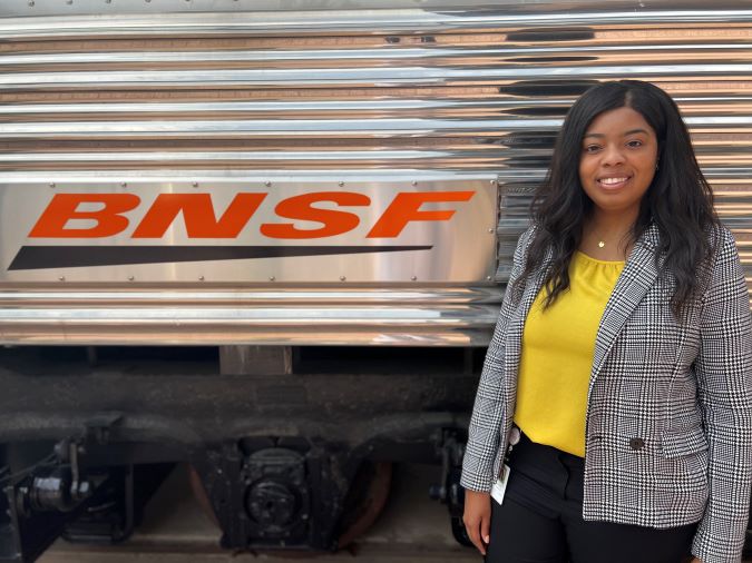 Jasmine Richard in front of a refurbished business car at BNSF’s headquarters in Fort Worth.